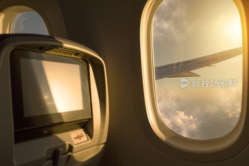 日落/日出天空鸟瞰图从机场起飞后的窗口飞机经济舱座位。